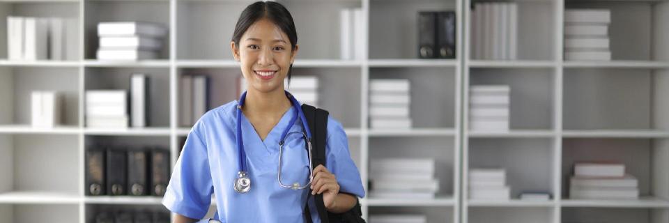 A STEM OPT student in medical scrubs holding a backpack and stethoscope, symbolizing healthcare graduates transitioning from F1 visa to EB5 Green Card.