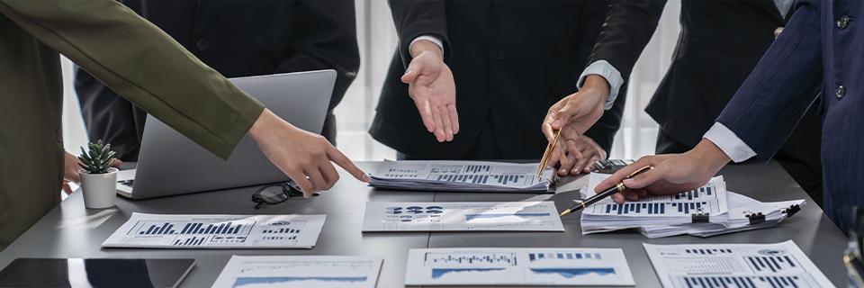 Team of EB5AN professionals discussing financial charts, reflecting strategic planning for EB5 investment and business expansion.