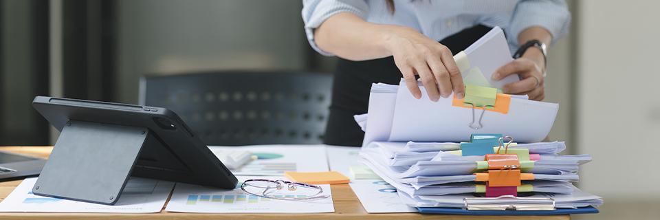 Hands sorting financial and immigration documents for EB5 investment, highlighting the paperwork needed to move from OPT to Green Card.