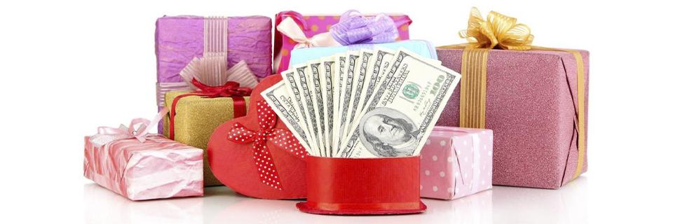 A stack of U.S. hundred-dollar bills inside a heart-shaped gift box, representing gifted funds used in EB5 investment petitions.