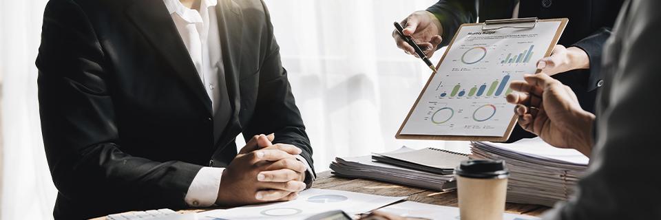 A group of professionals analyzing EB5 investment project charts, representing due diligence in evaluating business success factors.