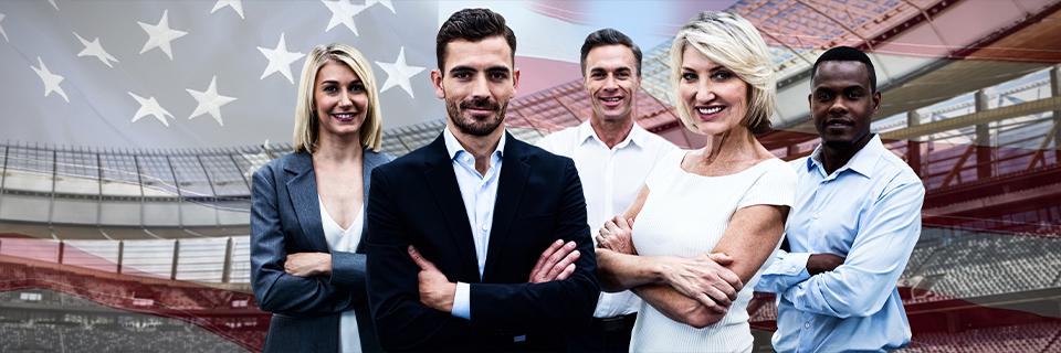 A diverse group of confident professionals standing in front of a U.S. flag backdrop, symbolizing visa options for skilled H-1B workers seeking permanent residency through EB5 or E2 investment routes.