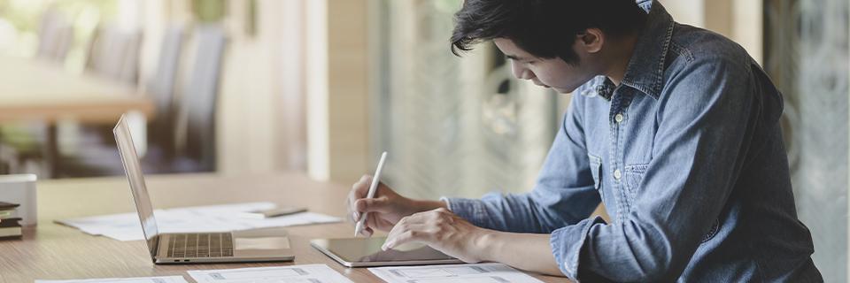 A focused individual preparing EB5 paperwork and reviewing project documentation to meet source of funds requirements for EB5 investors.