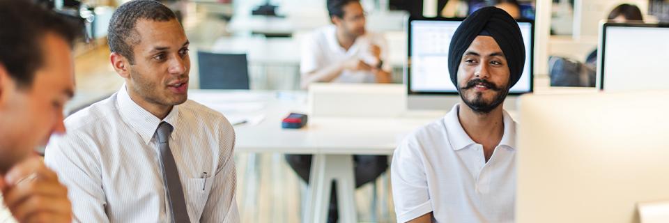 Indian H1B workers and international colleagues collaborating in a U.S. tech office, highlighting skilled immigrants exploring EB5 options.