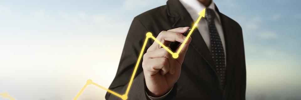A businessman drawing a rising arrow chart, reflecting the financial growth potential and long-term stability of EB5AN projects backed by single-family housing assets.