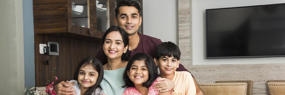 A happy Indian family at home, illustrating the benefits of EB5 visas for H1B holders seeking U.S. Green Cards for themselves and their children.