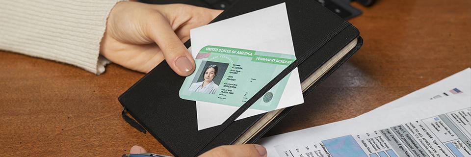 A conditional Green Card placed on a black notebook with supporting USCIS paperwork, symbolizing EB5 investors receiving U.S. permanent residency through investment.