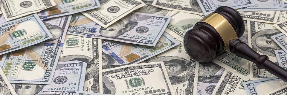 A judge’s gavel resting on U.S. dollars, representing legal scrutiny of EB5 investment funds and loan sources.