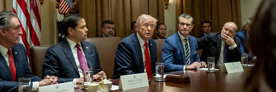 President Donald Trump speaking at a government meeting alongside advisors and officials, representing policy discussions affecting EB5 and Gold Card immigration programs.