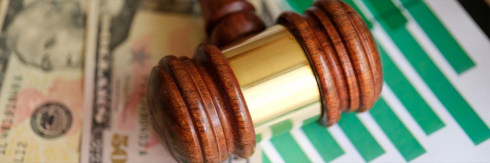 A gavel placed on financial charts and dollar bills, highlighting regulatory oversight in EB5 investment funding.