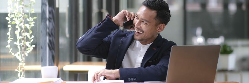 Smiling professional investor speaking on the phone, representing EB5 applicants managing their investment with minimal involvement through regional center support.
