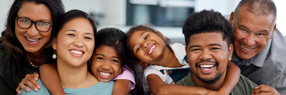 Happy multigenerational family posing together, representing relatives supporting one another in achieving permanent residency through the EB5 program.