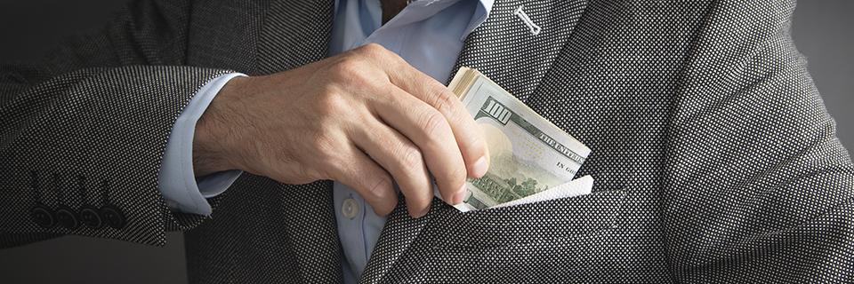 Investor putting cash into his jacket pocket, symbolizing the successful repayment of EB5 capital after project completion.