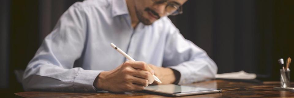 A professional completing immigration paperwork on a tablet, illustrating EB5 investors preparing I-526E, I-485, and related filings after job loss.