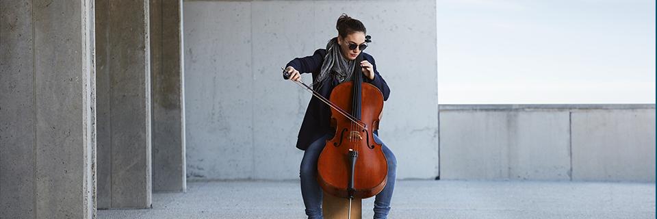 A musician performing on a cello in an urban setting, representing O1 visa options for artists and individuals with extraordinary ability.