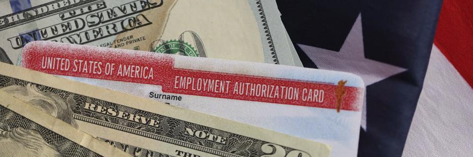 A U.S. employment authorization card placed over American currency and a flag, representing EB5 investors obtaining work authorization through concurrent filing.