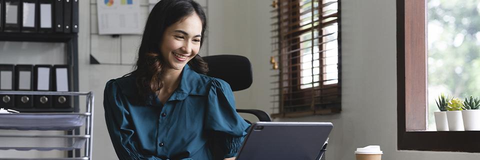 A professional woman working on a laptop in an office environment, representing the EB5 visa option for international professionals.