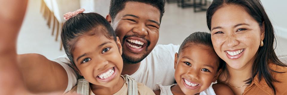 A smiling family with two children taking a selfie together, representing EB5 investors securing U.S. Green Cards for their immediate family members.