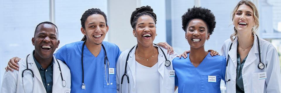 A diverse group of healthcare professionals standing together in a hospital setting, reflecting the career and employment opportunities available to EB5 Green Card holders and their families.