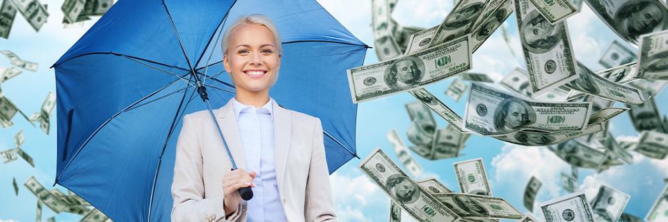 Business professional holding an umbrella as U.S. dollar bills fall around her, symbolizing wealth protection, currency stability, and EB5 investment as a hedge against inflation.