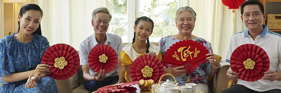 A multi-generational family celebrating together indoors, representing EB5 visa eligibility for spouses, children under 21, and family unity across generations.