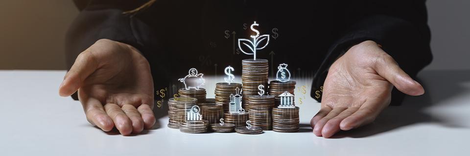 Stacks of coins with growth and finance icons held between open hands, representing EB5 investors protecting and growing capital through stable U.S. investments.