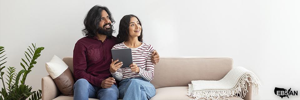 A couple reviewing information on a tablet at home, representing EB5 investors planning their family’s immigration strategy and long-term life in the United States.