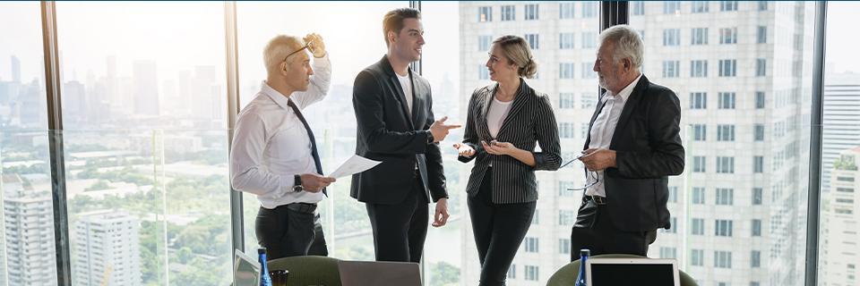 Group of executives discussing project progress in a modern office, representing collaboration and clear communication between EB5 regional centers and investors.