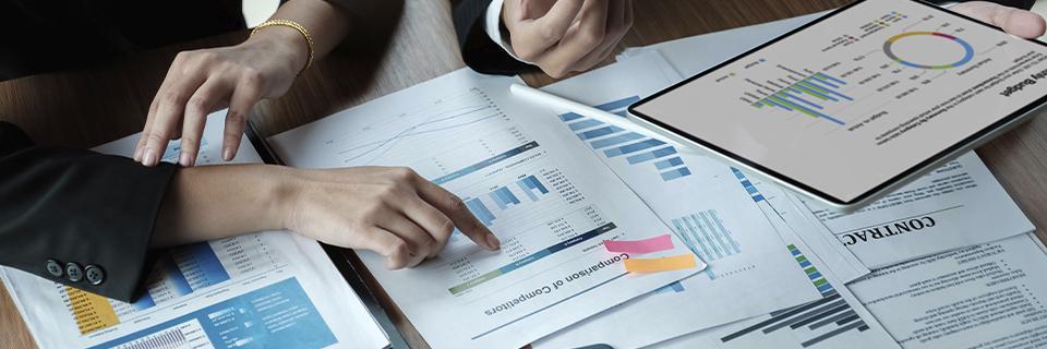 Investment team analyzing performance data and compliance reports on tablet and documents, symbolizing accountability and open communication in EB5 projects.