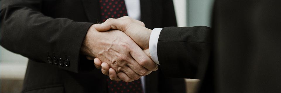 Close-up of two professionals shaking hands, symbolizing EB5 investment partnerships, trust, and collaboration between investors and project developers.